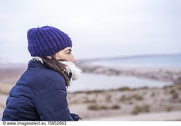 Seitenansicht einer Frau mit Wollmütze mit Blick auf den Horizont
