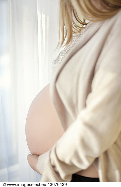 Seitenansicht Mittelteil einer schwangeren Frau zu Hause