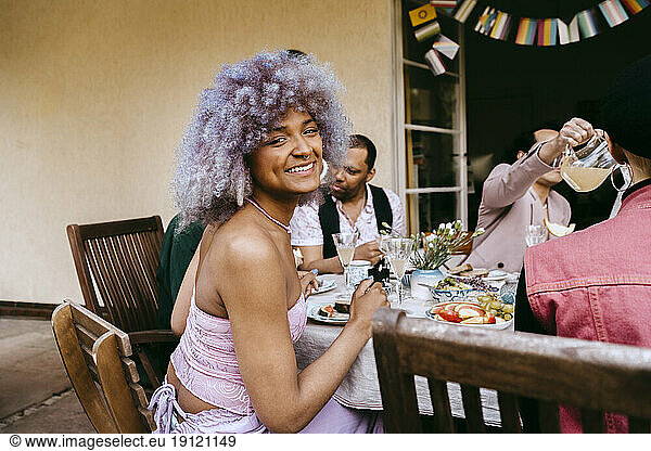 Seitenansicht Porträt der glücklichen Transfrau mit Freunden beim Abendessen Partei im Hinterhof