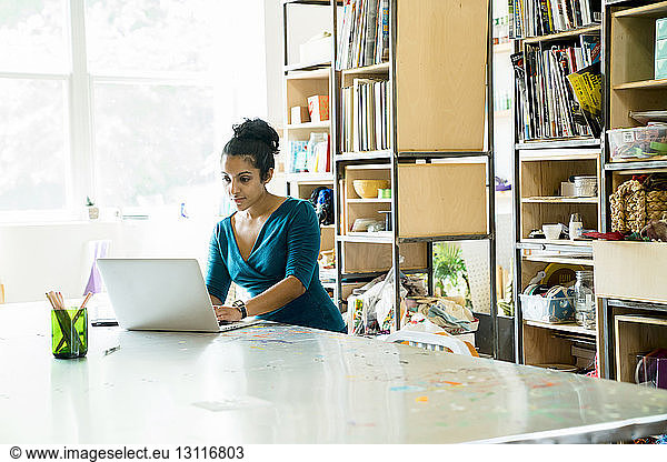 Selbstbewusste Geschäftsfrau  die am Laptop-Computer am Tisch im Büro arbeitet