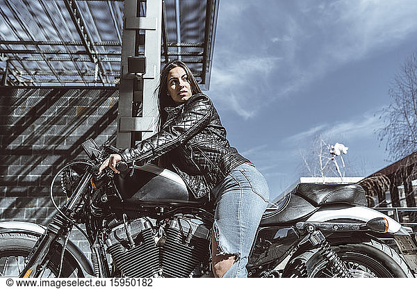 Selbstbewusste junge Frau auf Motorrad