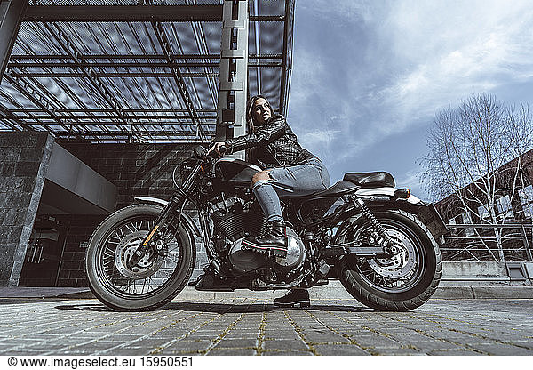 Selbstbewusste junge Frau auf Motorrad