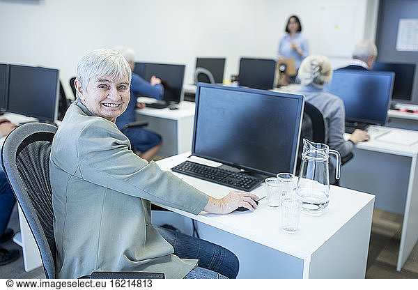 Selbstbewusste Seniorin bei einem Computerkurs
