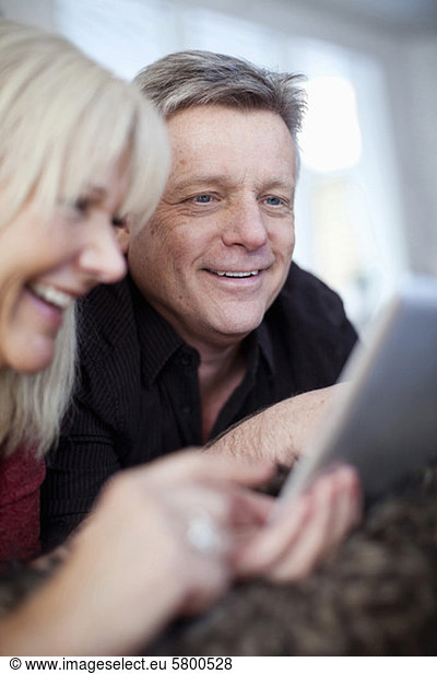 Selective focus of couple using digital tablet at home