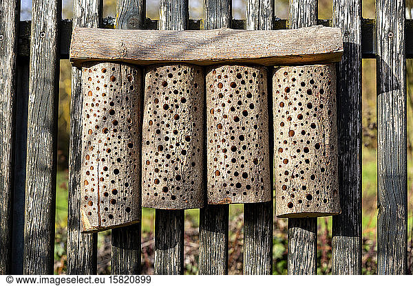 Self-built bee hotel on a wooden fence
