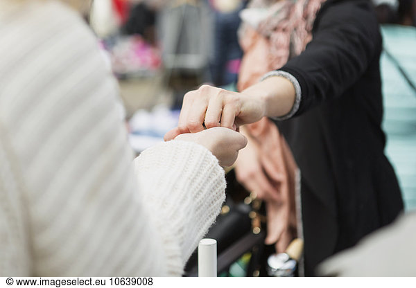 Seller giving something to woman at flea market