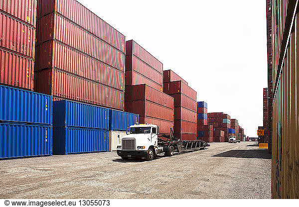 Semi-truck by cargo containers at commercial dock
