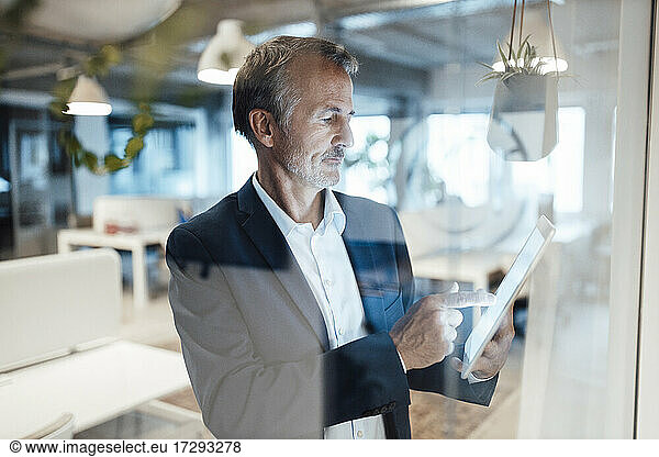 Senior businessman using digital tablet in office