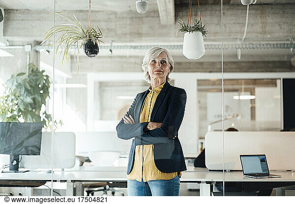 Senior businesswoman with arms crossed at office