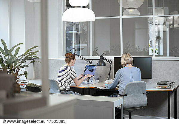 Senior businesswoman working with colleague in office