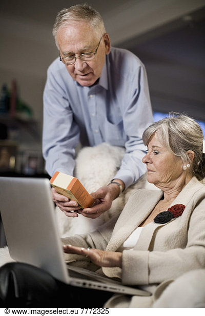 Senior couple checking product details on laptop