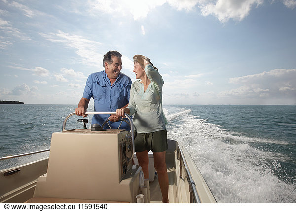 Senior couple driving motorboat