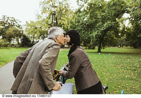 Senior couple kissing on mouth in park during vacation