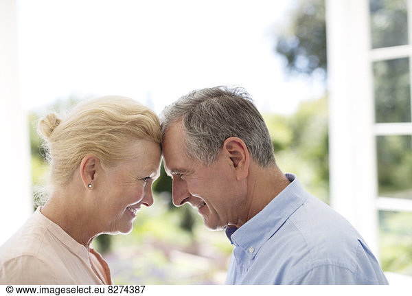 Senior couple leaning head to head