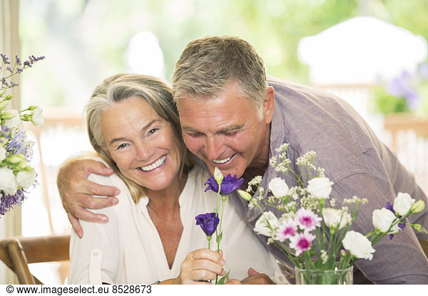 Senior couple smelling flowers