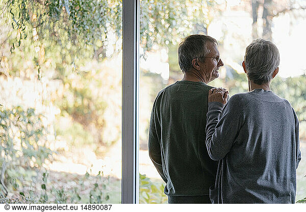 Senior couple standing at panorama window