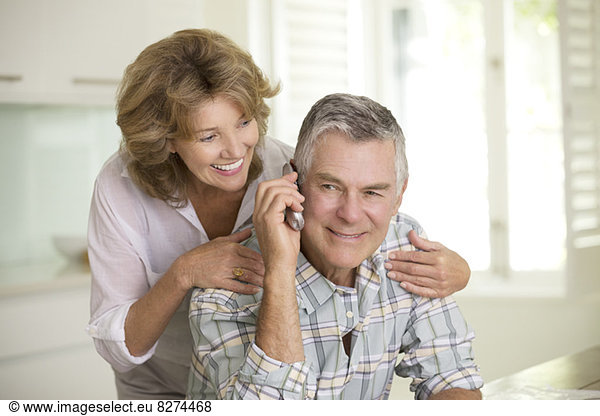 Senior couple talking on telephone
