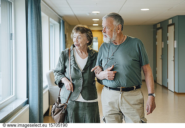 Senior couple walking arm in arm at elderly nursing home