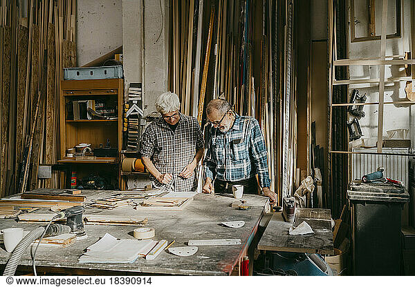 Senior craftsmen working together at carpentry workshop