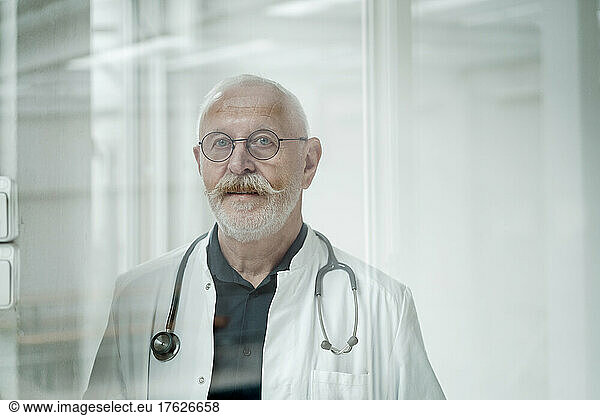 Senior doctor with mustache wearing eyeglasses at medical clinic