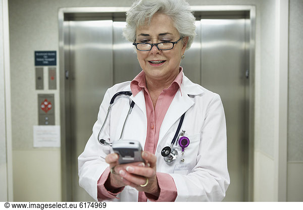 Senior female doctor using electronic organizer