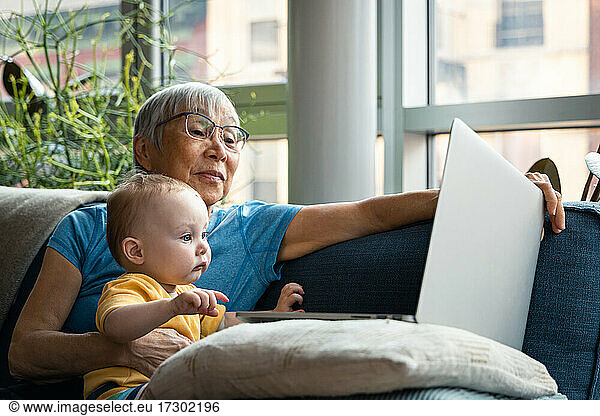 Senior Grandparent and Granddaughter looking at computer together