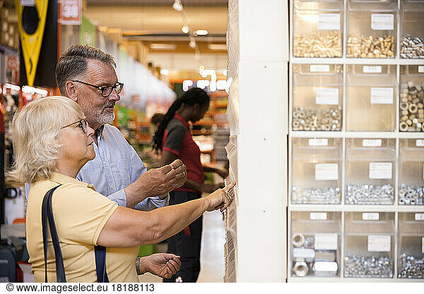 Senior male and female customers choosing merchandise at hardware store