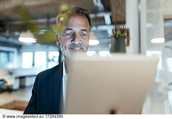 Senior male entrepreneur using digital digital at office