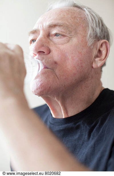 Senior man drinking mineral water