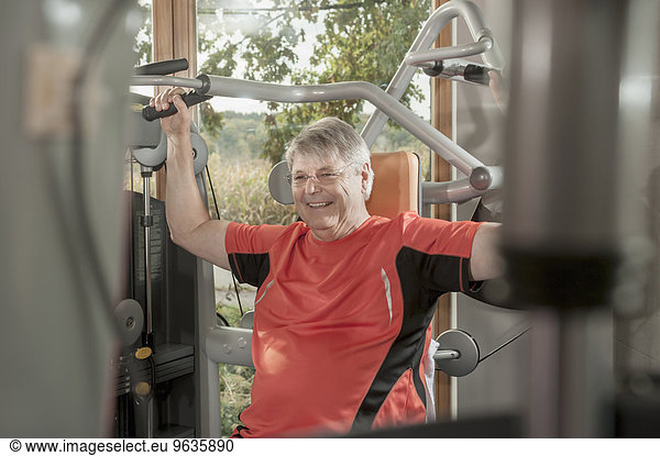 Senior man fitness studio weight training
