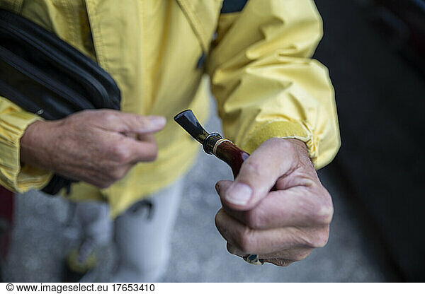Senior man holding cigar pipe in hand