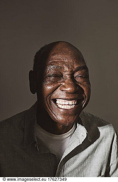 Senior man laughing over white background
