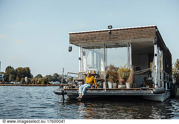 Senior man relaxing at houseboat on sunny day