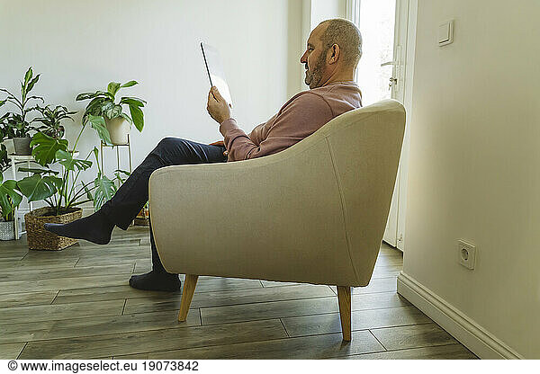 Senior man using tablet PC at home