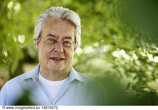 Senior man with gray hair smiling in park