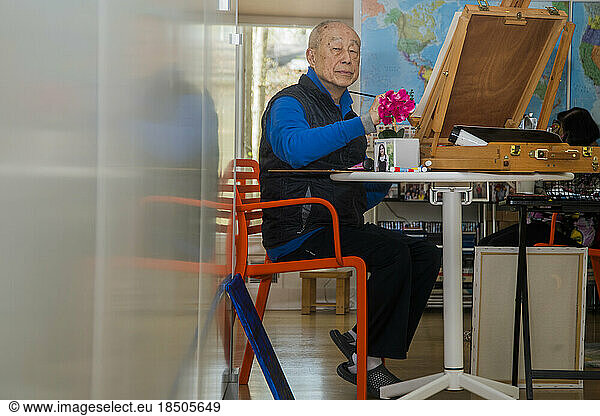 Senior retiree painting in the afternoon