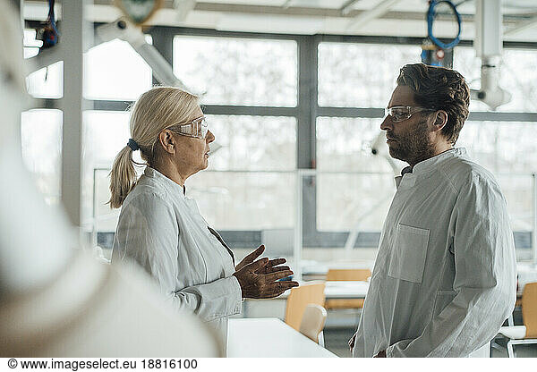 Senior scientist discussing with colleague in laboratory