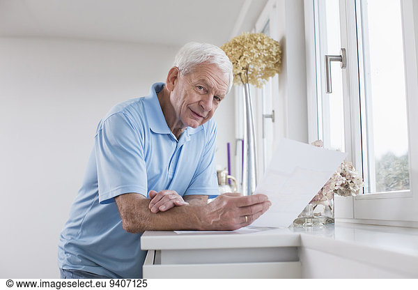 Senior Senioren Mann Papier halten Tuch