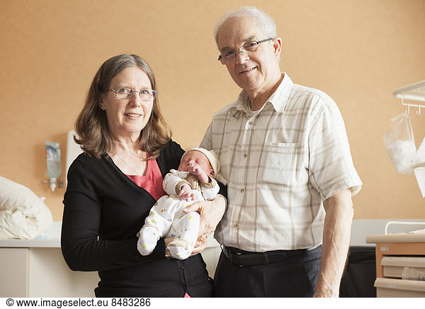 Senior Senioren Neugeborenes neugeboren Neugeborene Europäer halten Enkelsohn