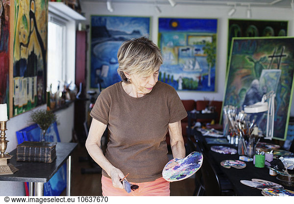 Senior Senioren Pinsel halten Bürste Farbe Farben Studioaufnahme Künstler bemalen