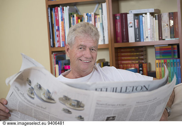 Senior Senioren Portrait Mann lächeln Zeitung vorlesen