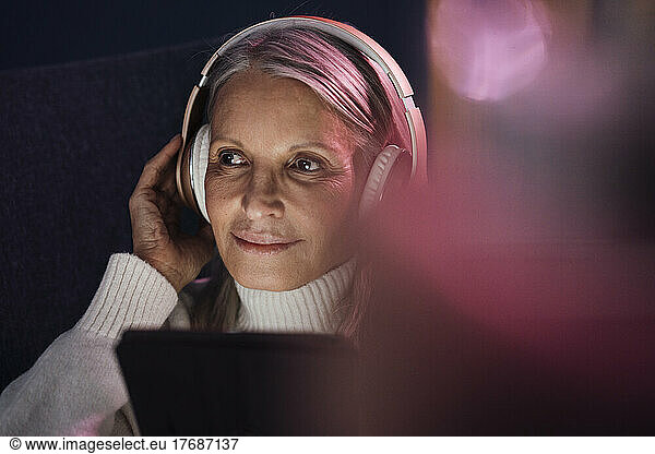 Senior woman adjusting wireless headphones