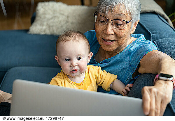 Senior woman and granddaughter doing video call through laptop