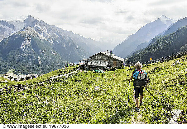 Senior woman approaching mountain hut  Haute Route  Valais Canton  Switzerland