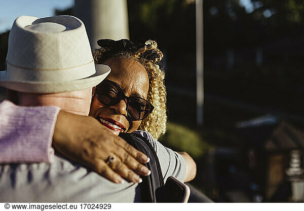 Senior woman embracing man on sunny day