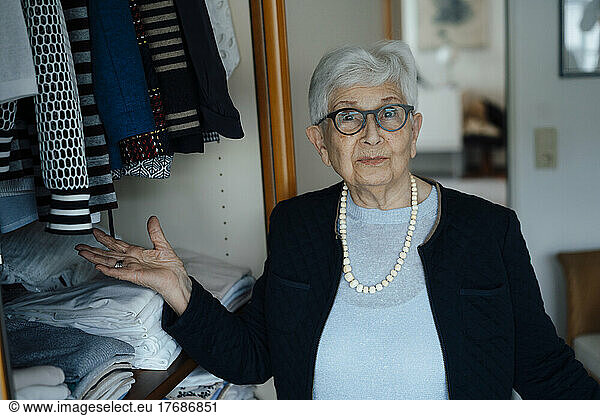 Senior woman gesturing at closet in wardrobe