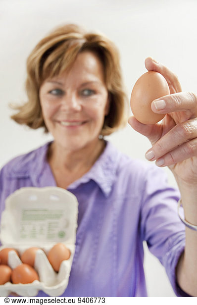 Senior woman holding egg  smiling