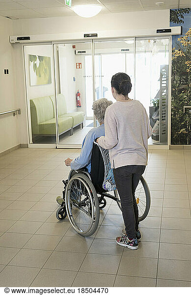 Senior woman in wheelchair with girl in rest home