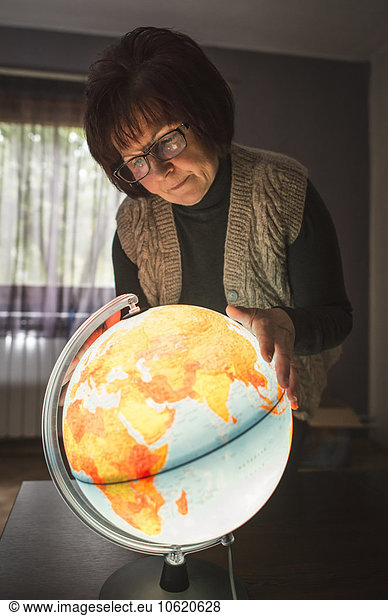 Senior woman looking at lighted globe