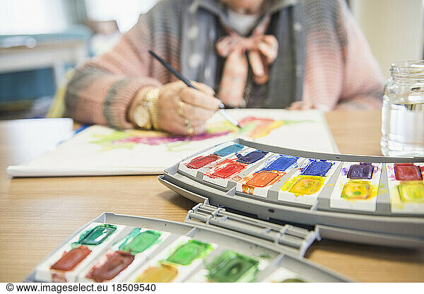 Senior woman painting fruit using water color